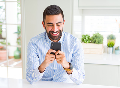 un homme content de recevoir un message sur son cellulaire