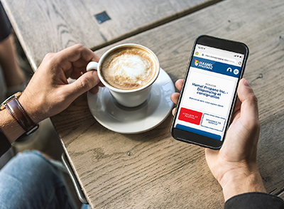 quelqu'un qui regarde l'espace client sur son cellulaire en buvant du café