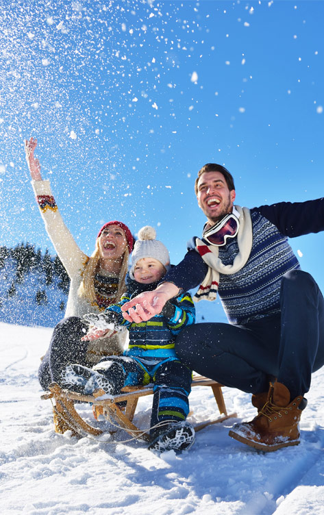 Jeune famille qui joue dehors dans la neige