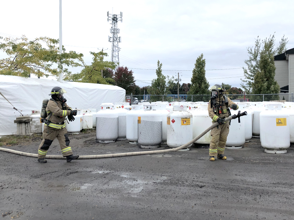 Deux pompiers tenant un boyau
